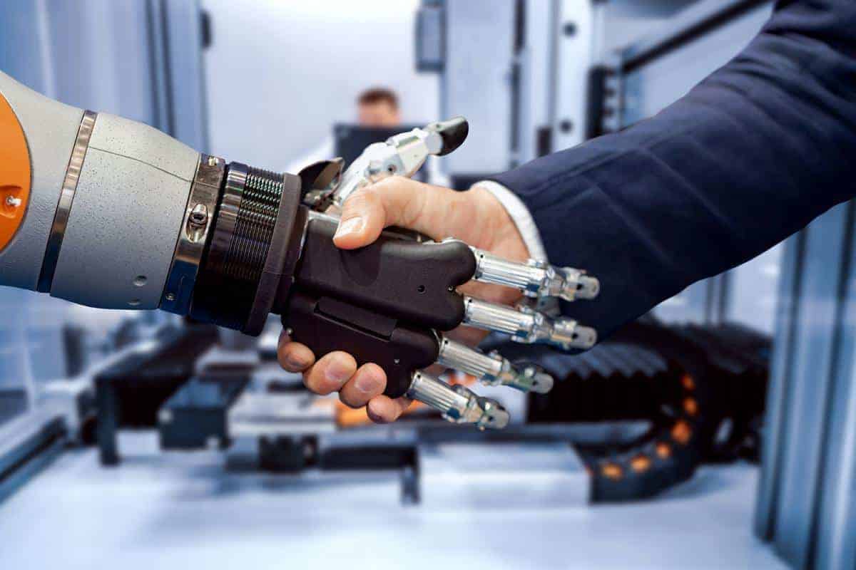 Hand of a businessman shaking hands with a Android robot.