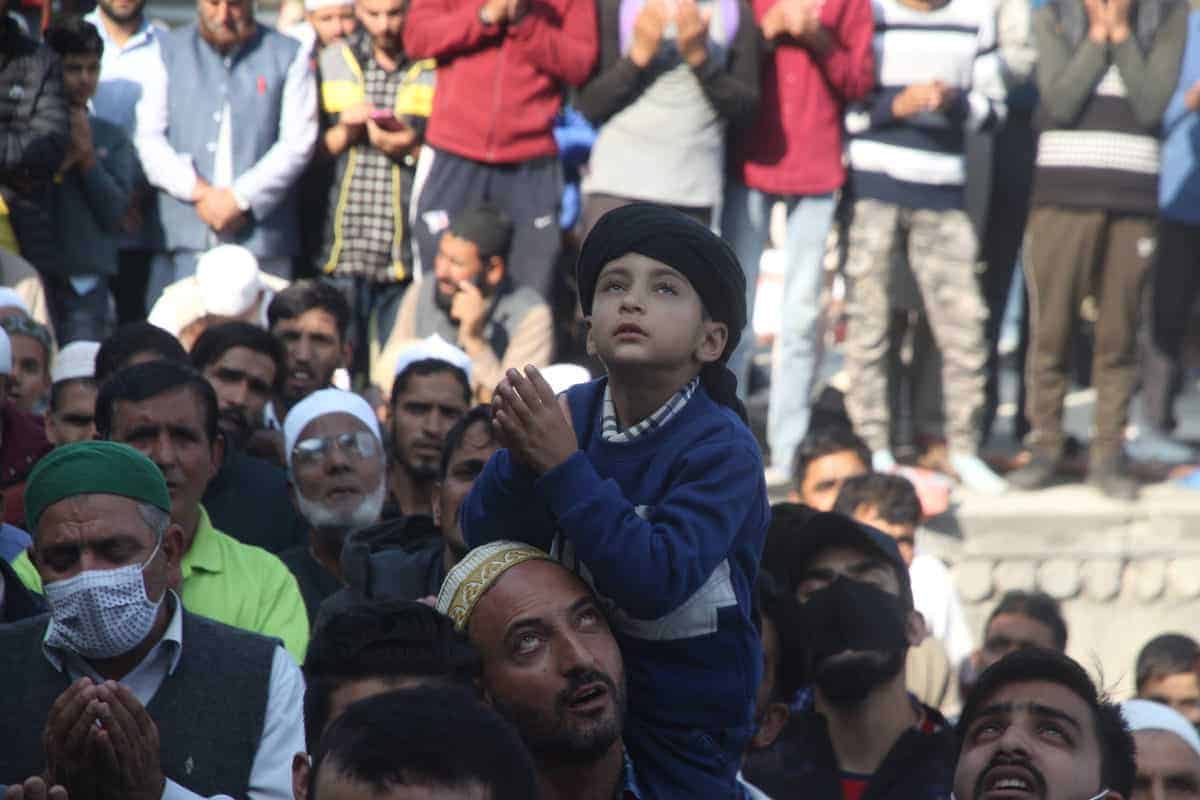 A kid making dua while he takes a glimpse of holy relic at Hazratbal Shrine in Srinagar